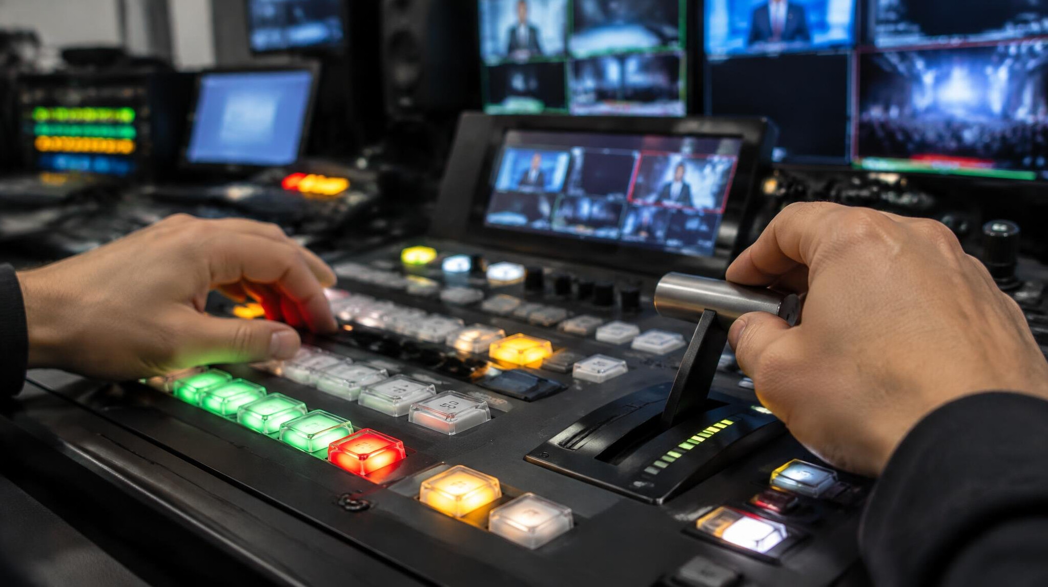 Close-up of hands operating a vision mixer switcher panel