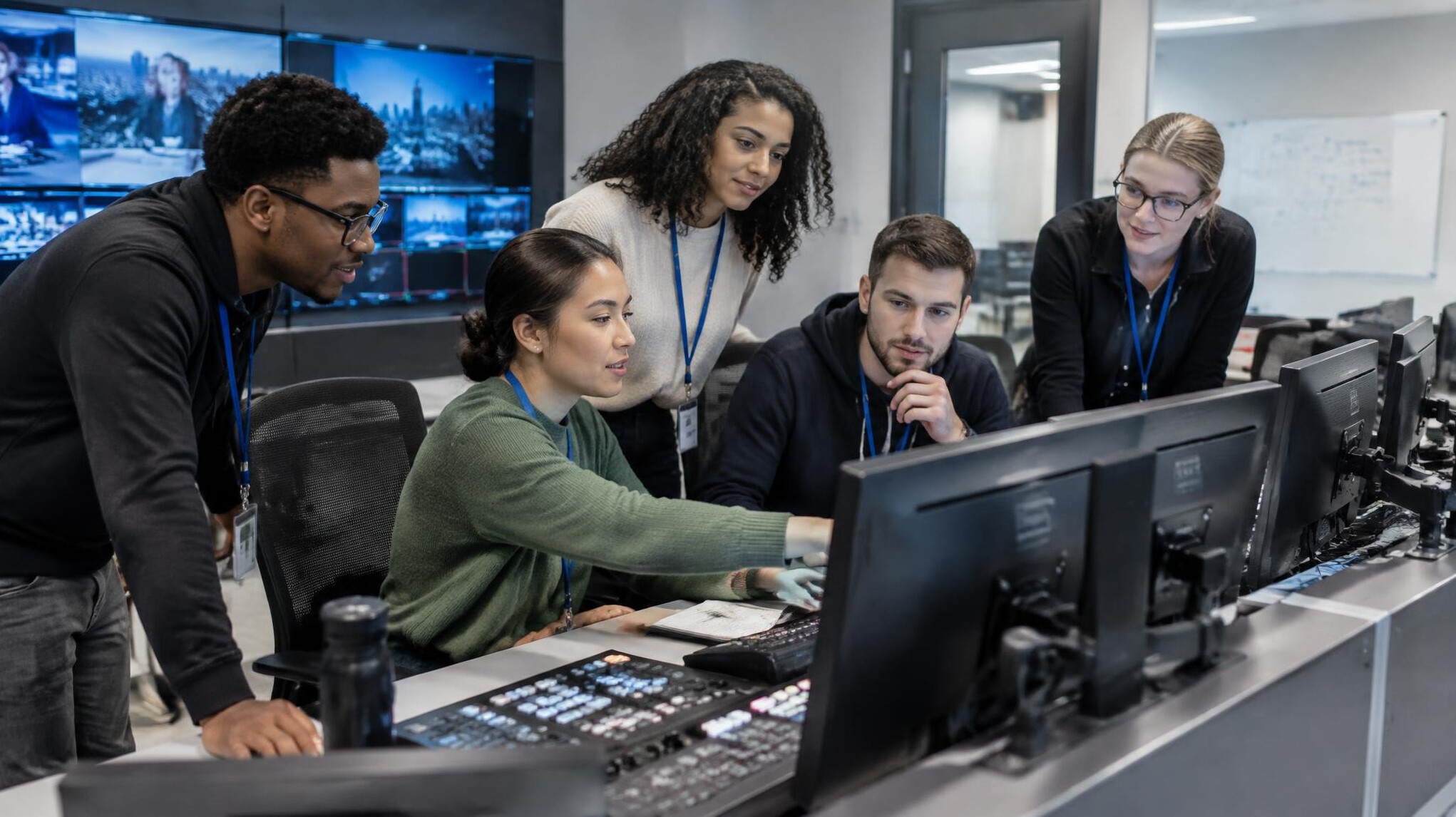 Group of trainees working together in a live production control room